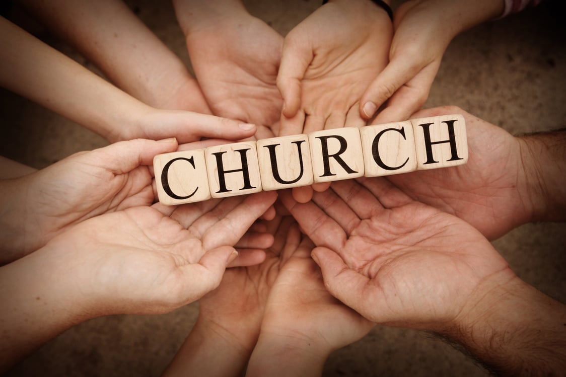 A group of people holding wooden blocks with the word "church". (No gender, age, or ethnicity information is mentioned in the description.)