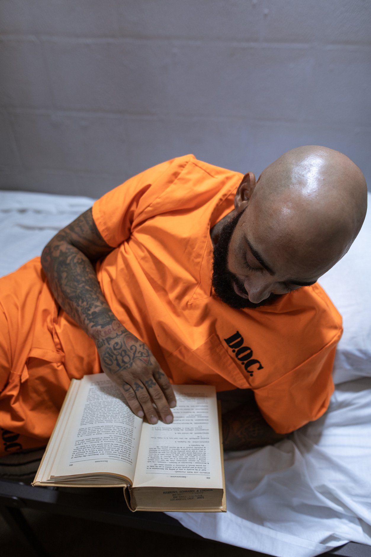 a person in an orange prison uniform is reading a book